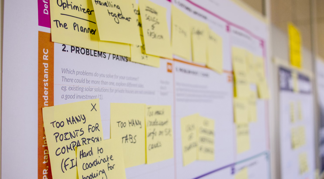 A bulletin board with sticky notes attached to it.